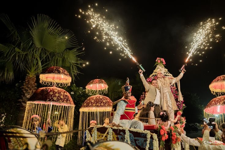 Grand night baraat celebration on decorated vehicle with sparkler pyro and royal chhatri umbrellas